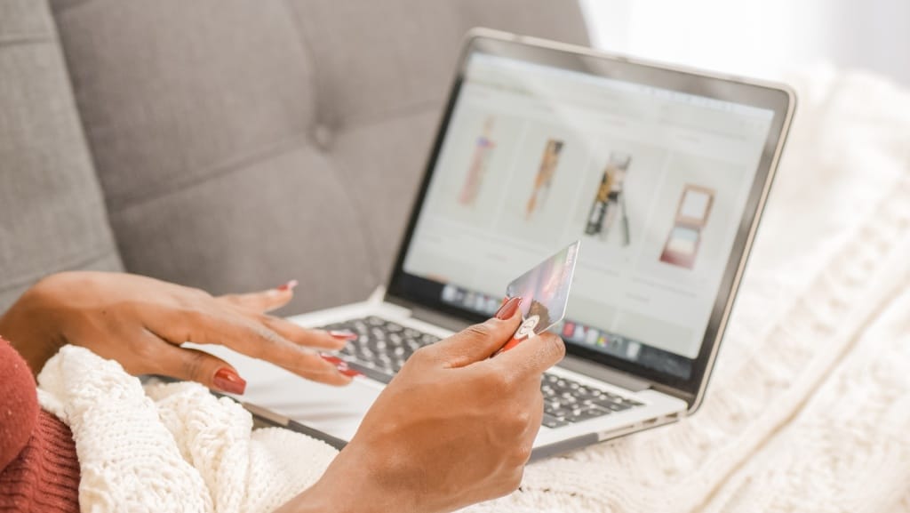 Person holding Credit card looking at laptop